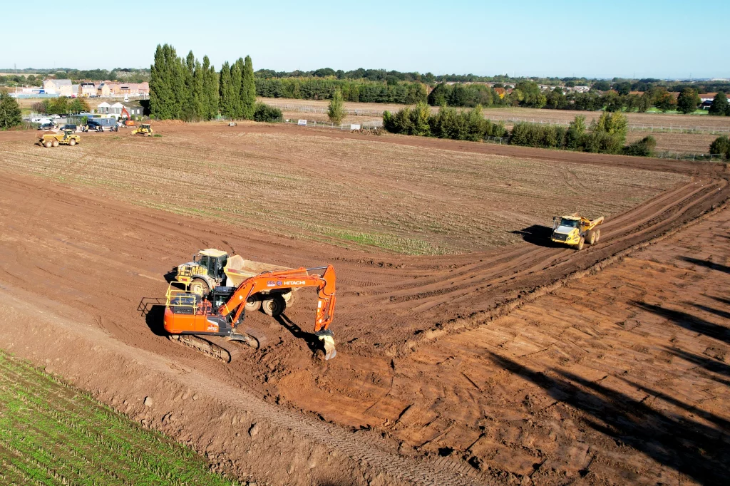 DDG Group branded Digger and dump trucks starting the groundworks for a large-scale commercial project. Groundworks.